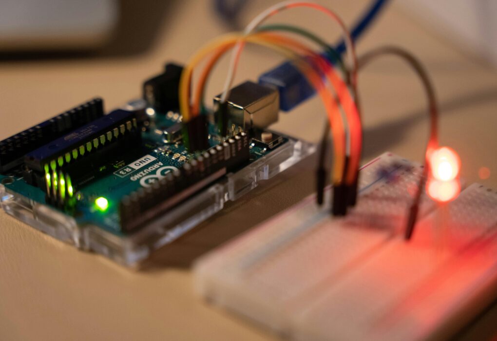 Close-up of Arduino microcontroller connected to a breadboard with a glowing LED.